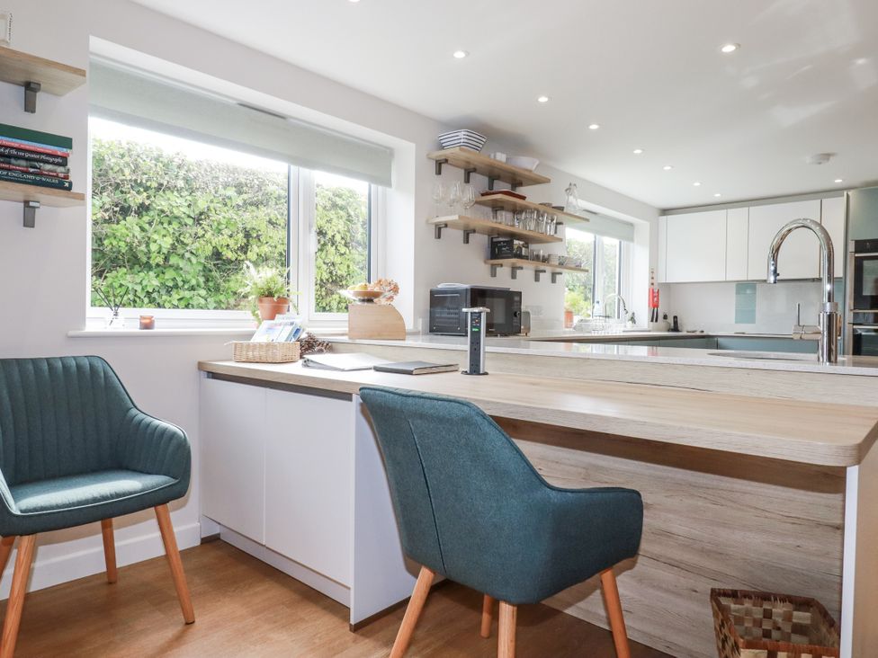 A kitchen with a counter and two chairs at Hillbre in Trevone