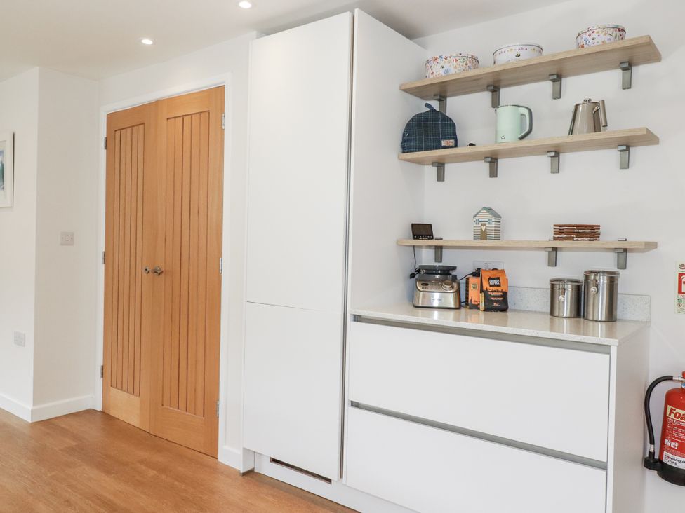 A kitchen with cabinets and appliances at Hillbre Trevone