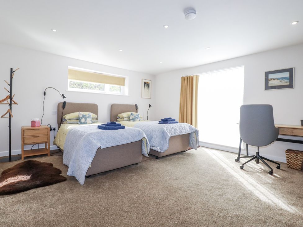 A bedroom with two beds and a desk at Hillbre in Trevone