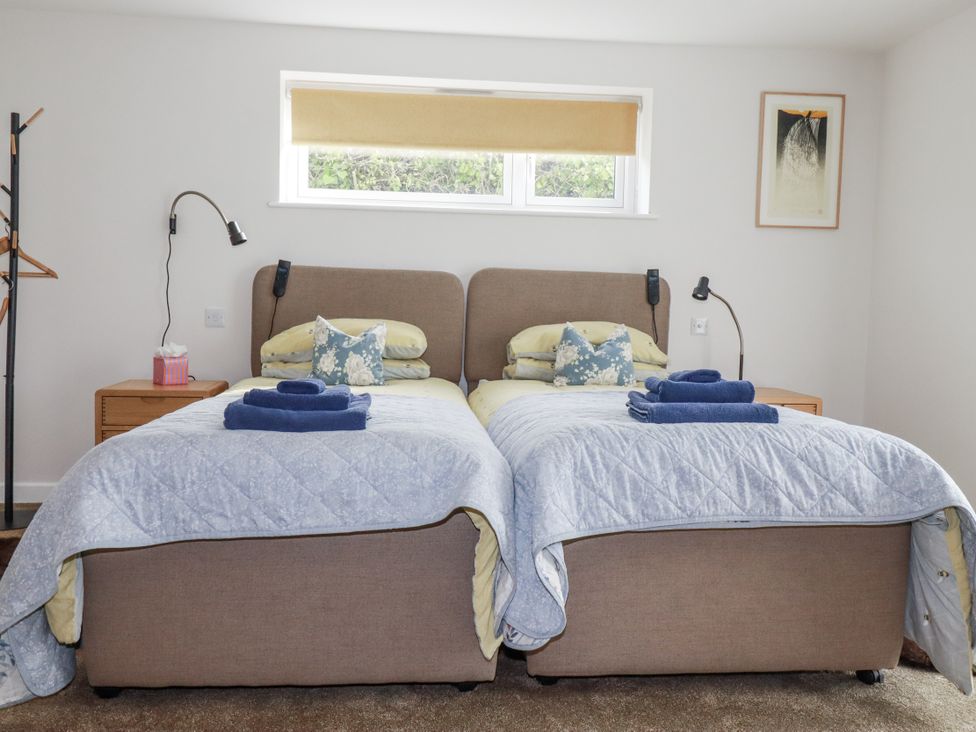 A bedroom with twin beds and bedside table at Hillbre in Trevone