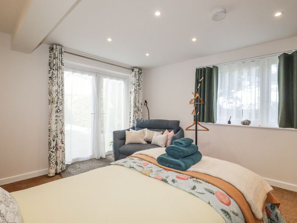 A bedroom with a bed and a sofa at Hillbre in Trevone