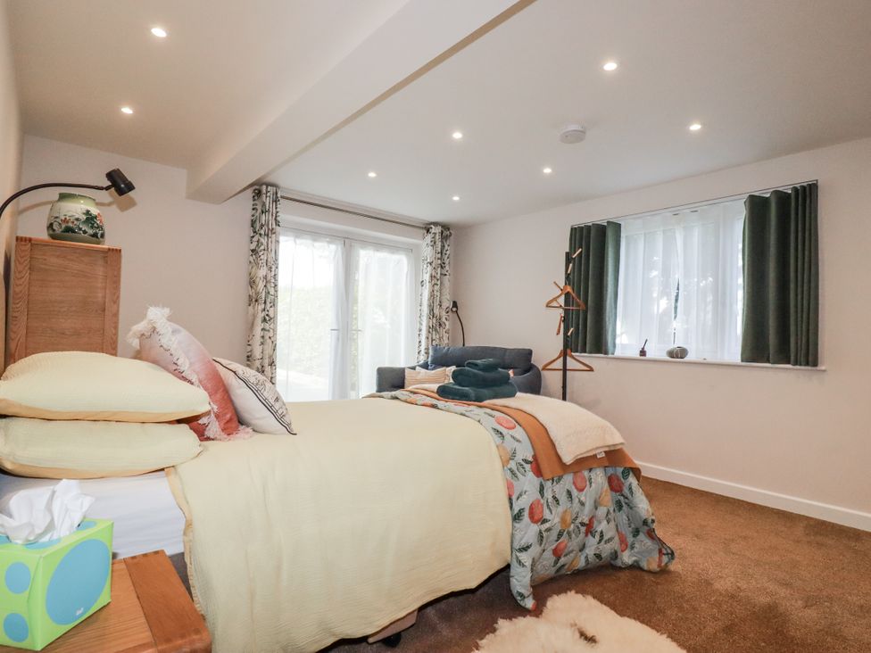 A bedroom with a bed and sofa at Hillbre in Trevone