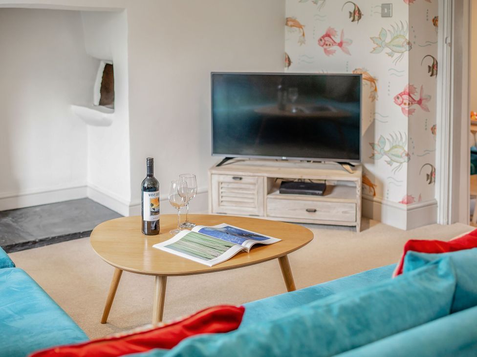 A living room with a television and coffee table at Summerleaze Cottage 2 Spa in Bude