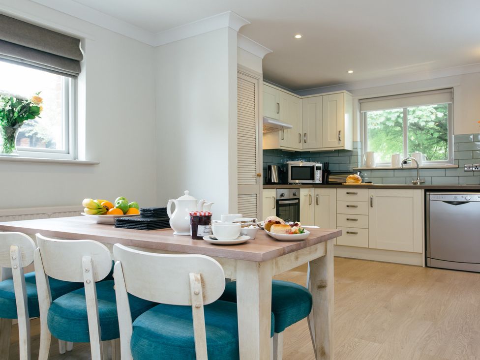A kitchen with dining table and chairs at Summerleaze Cottage 2 Spa in Bude