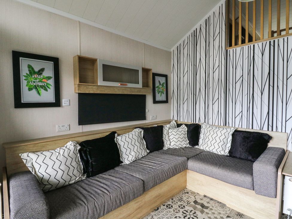 A living room with a sofa and wall art at The Family Pod in Swansea
