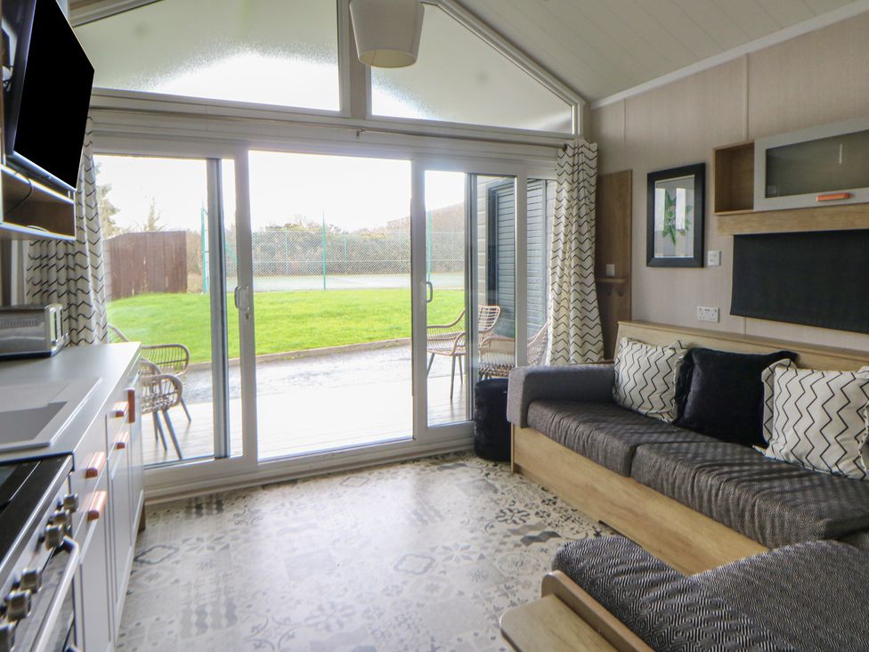 A living room with a sofa and television at The Family Pod in Swansea