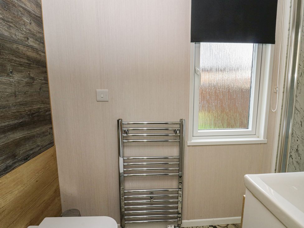 A bathroom with a window and towel rail at The Family Pod in Swansea