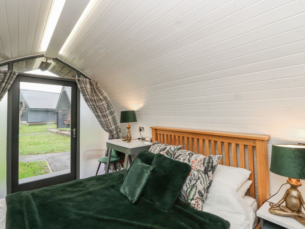 A bedroom with a bed and a table at Garden Lodge 1 Swansea