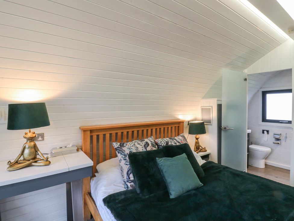 A bedroom with a bed and an attached bathroom at Garden Lodge 1 in Swansea