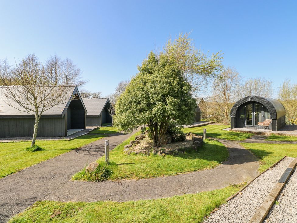 An outdoor view of cabins and landscaped area at Glamping Pod 1, Oldwalls, Llanrhidian, Gower