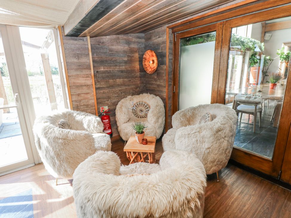 A seating area with circular chairs and a table at Glamping Pod 1 Oldwalls, Llanrhidian, Gower