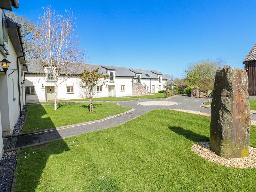 An outdoor area with buildings and a stone at Glamping Pod 1 Oldwalls, Llanrhidian, Gower