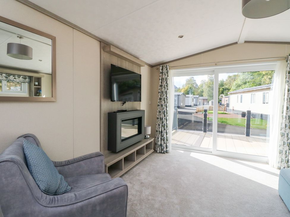 A living room with a sofa and television at Altair Lodge in 