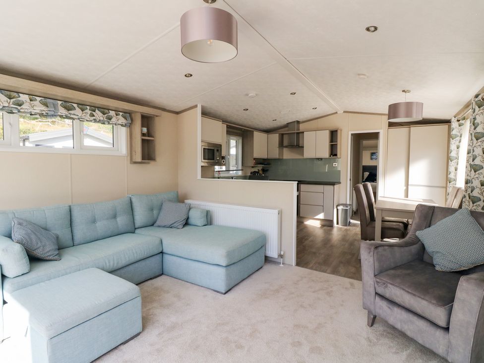 A living room with a sofa and dining table at Altair Lodge