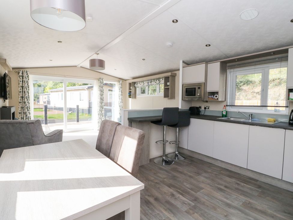 A kitchen with dining table and open layout at Altair Lodge