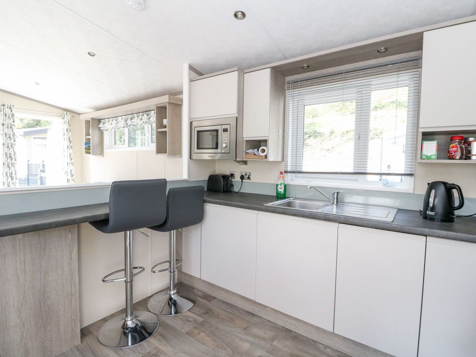A kitchen with bar stools and a sink at Altair Lodge