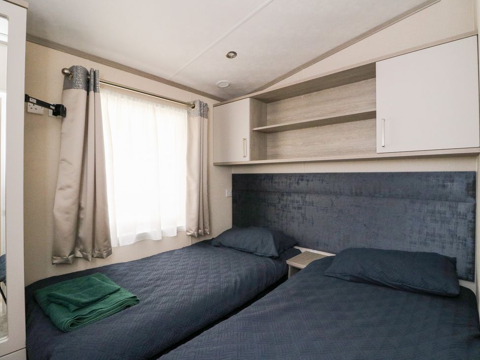 A bedroom with two beds and a shelf at Altair Lodge in 