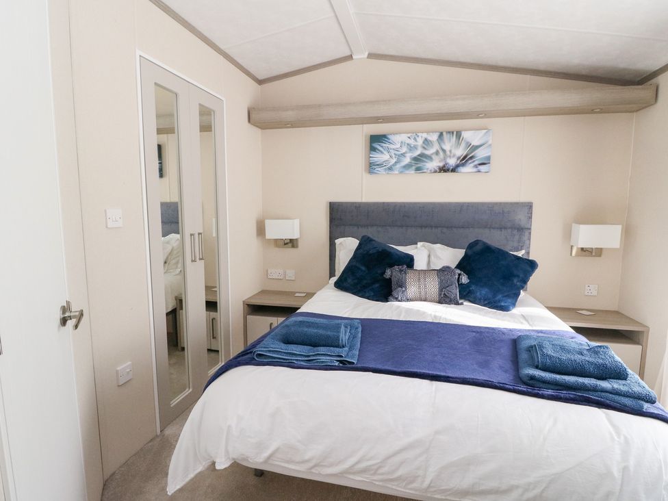 A bedroom with a bed and mirror at Altair Lodge 