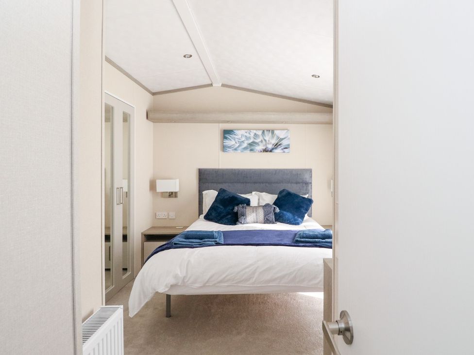 A bedroom with a bed and wardrobe at Altair Lodge