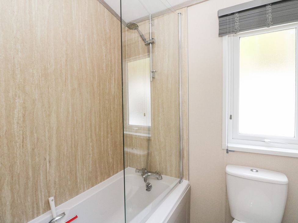 A bathroom with a bathtub, shower, and toilet at Altair Lodge