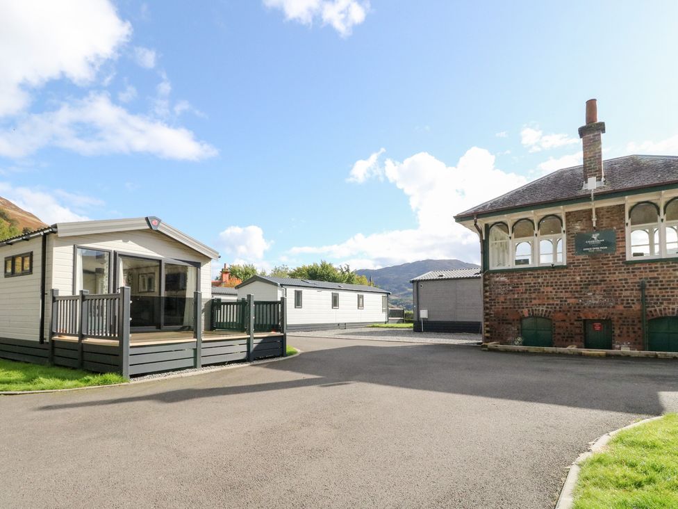 An outdoor area with caravans and a brick building at Altair Lodge in 