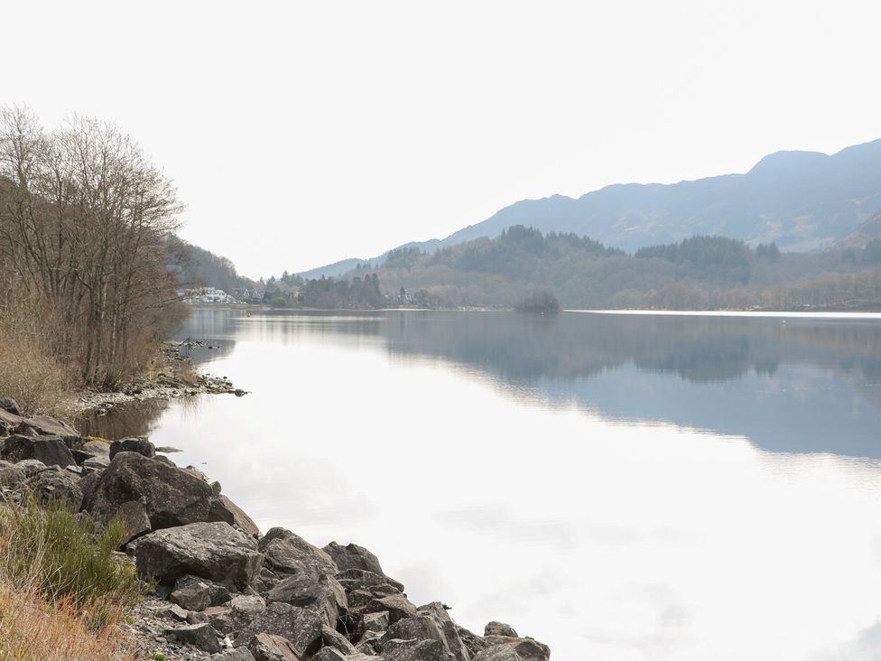 A lake surrounded by trees and mountains at Altair Lodge 