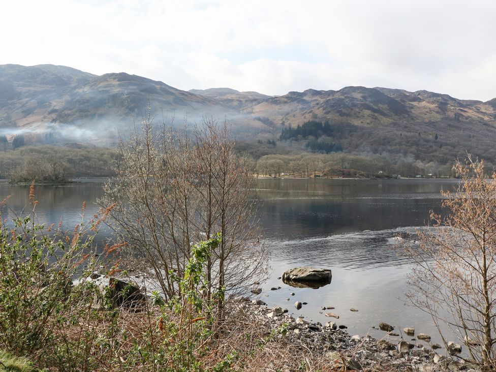 A lake with mountains and trees at Altair Lodge
