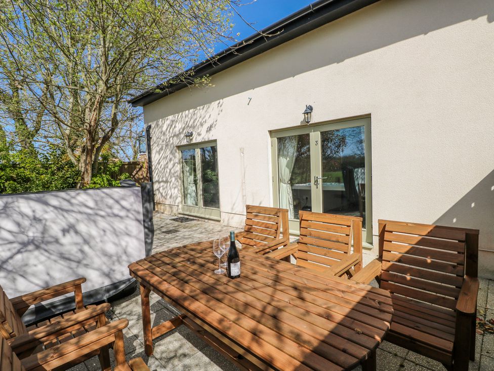 An outdoor area with a wooden table and chairs at Oak Tree Cottage in Oldwalls, Llanrhidian, Gower
