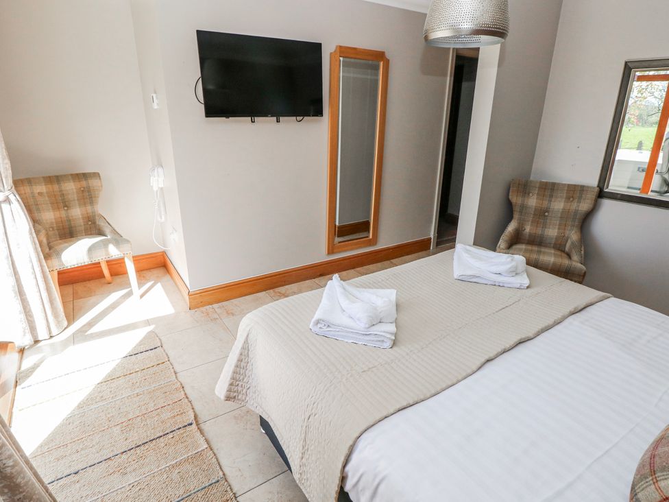 A bedroom with a bed and a television at Oak Tree Cottage Oldwalls, Llanrhidian, Gower