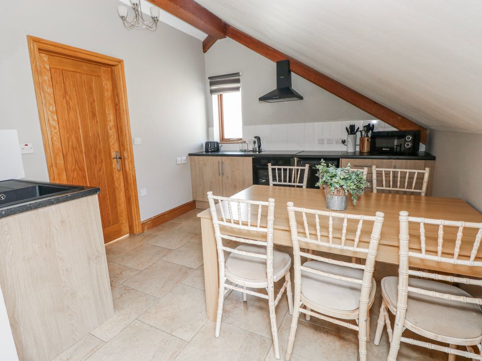 A kitchen with a dining table and chairs at Oak Tree Cottage Oldwalls, Llanrhidian, Gower