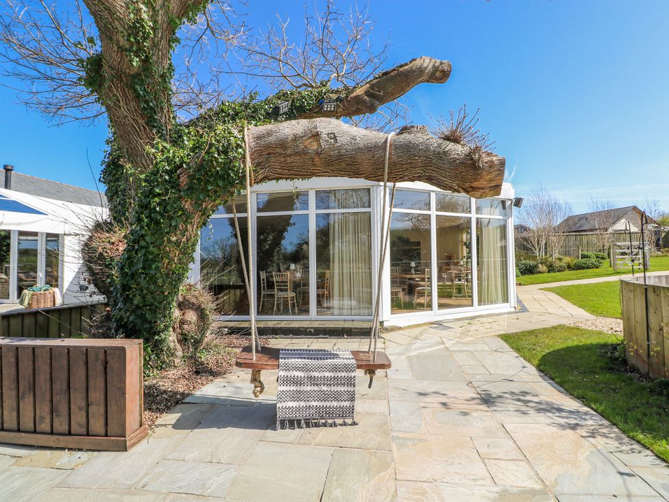 An outdoor area with a swing hanging from a tree at Oak Tree Cottage in Oldwalls, Llanrhidian, Gower
