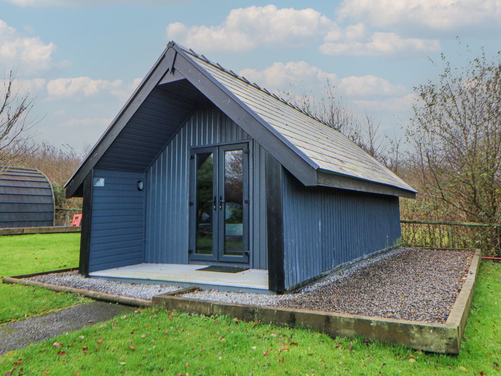 A cabin with a gravel path and grass area at Garden lodge 3 Swansea