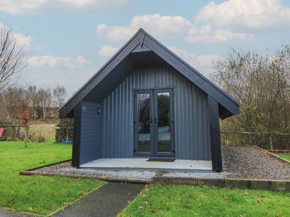 A cabin with a gravel path and grass area at Garden lodge 3 Swansea