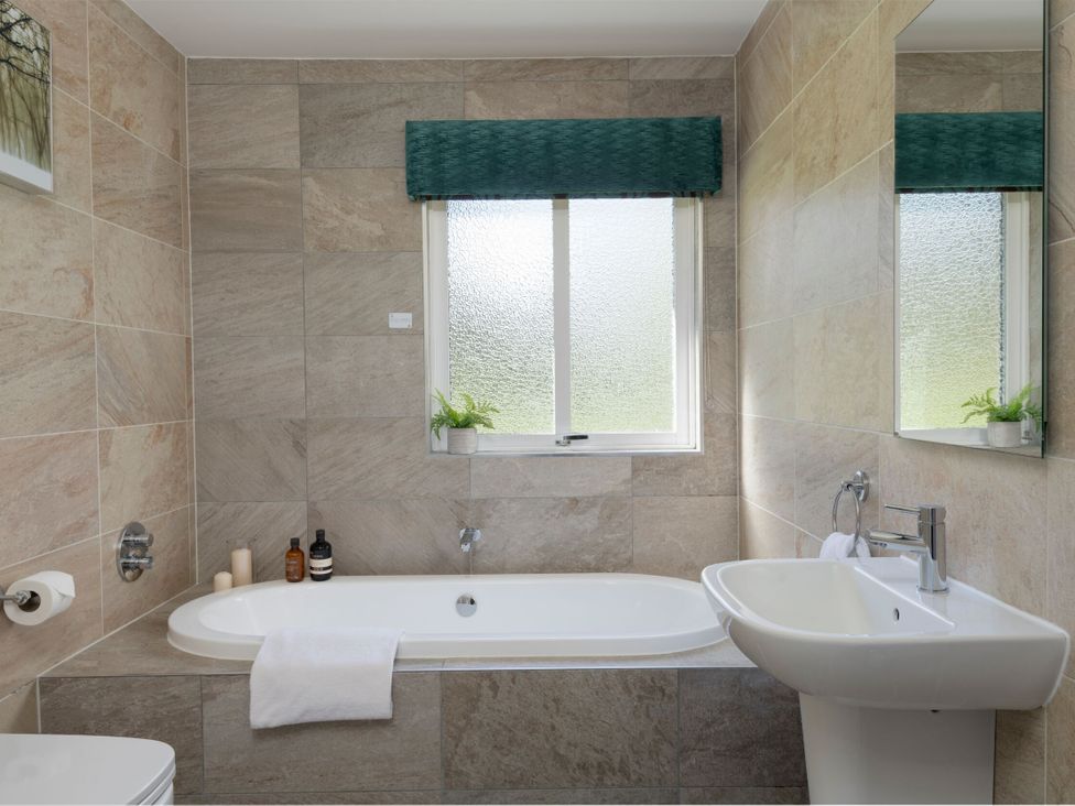 A bathroom with a bathtub, toilet, and sink at The Allensford in Slaley