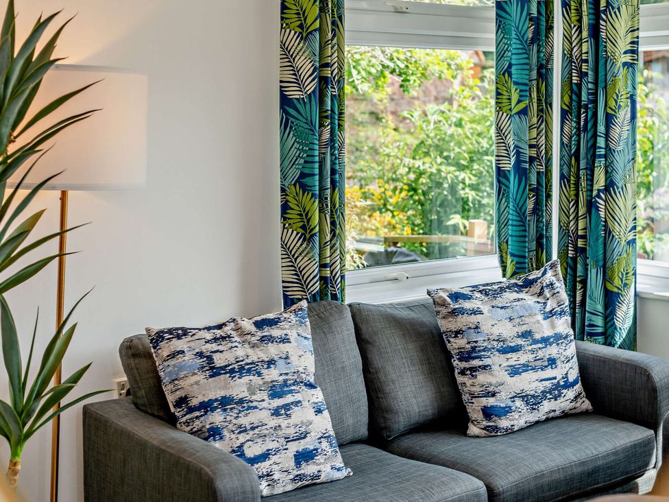 A living room with a sofa and cushions at Kernow Nook Spa Perranporth