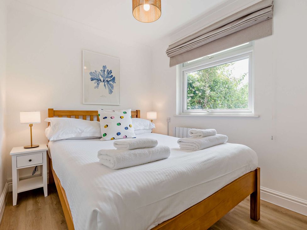 A bedroom with a bed and nightstand at Kernow Nook Spa in Perranporth