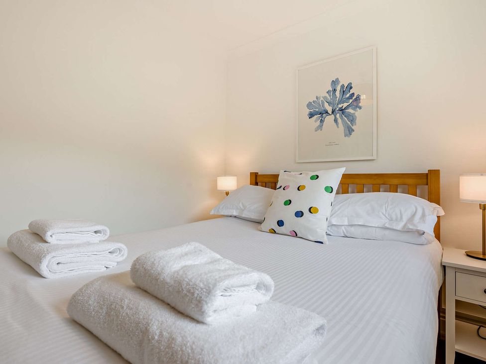 A bedroom with towels on the bed at Kernow Nook Spa in Perranporth