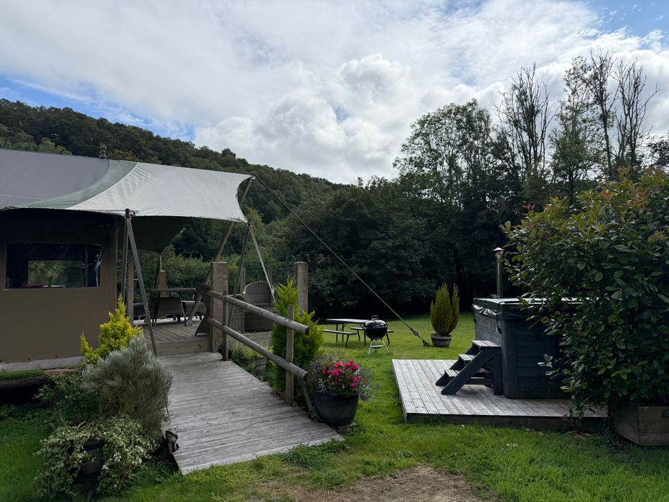 An outdoor area with a tent, deck, hot tub and furniture at Ceri in Newcastle Emlyn