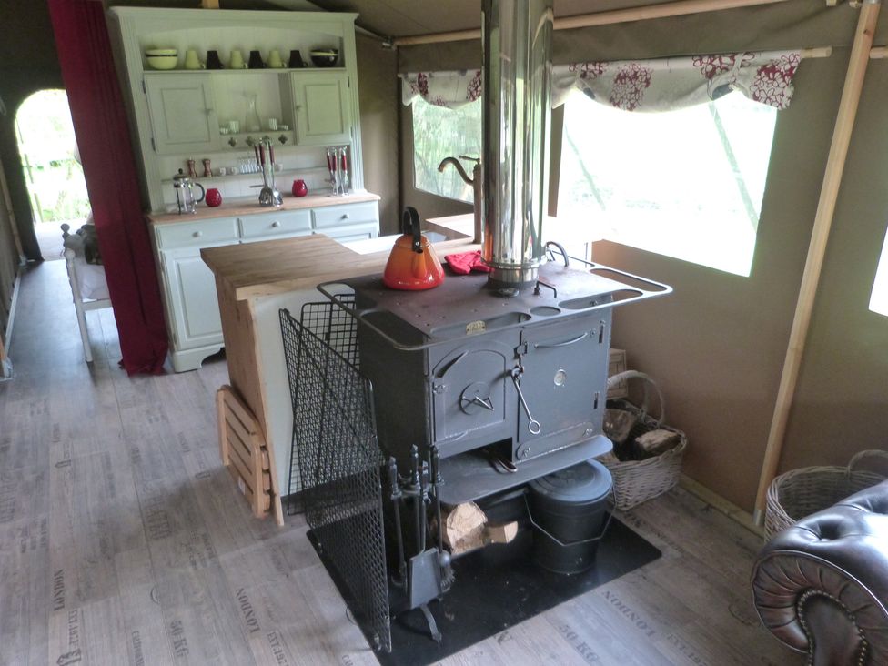 A kitchen with a wood stove and shelves at Ceri in Newcastle Emlyn