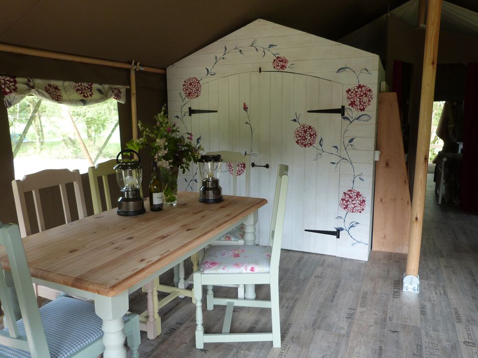 A dining room with a wooden table and chairs at Ceri in Newcastle Emlyn