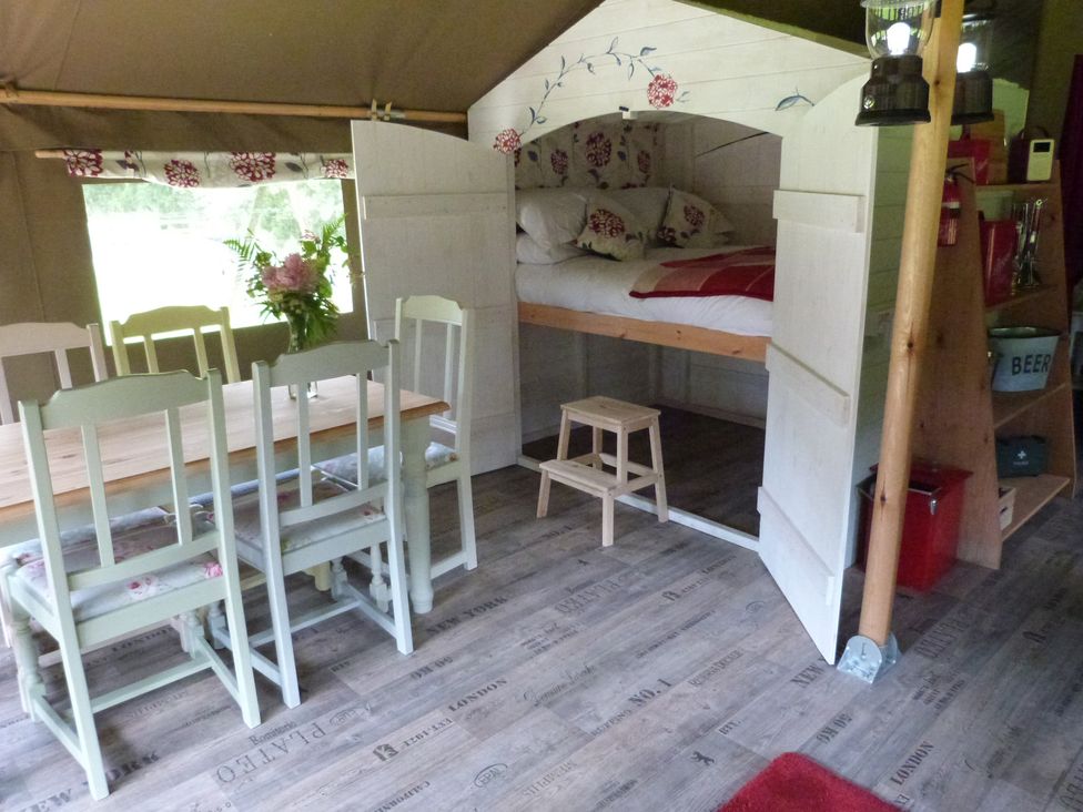 A dining area with a table and chairs beside a bed at Ceri in Newcastle Emlyn
