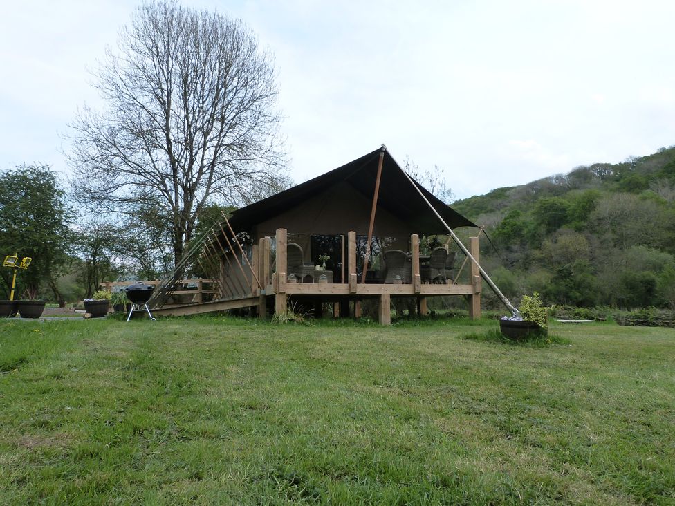A tent structure with a deck and chairs at Ceri in Newcastle Emlyn