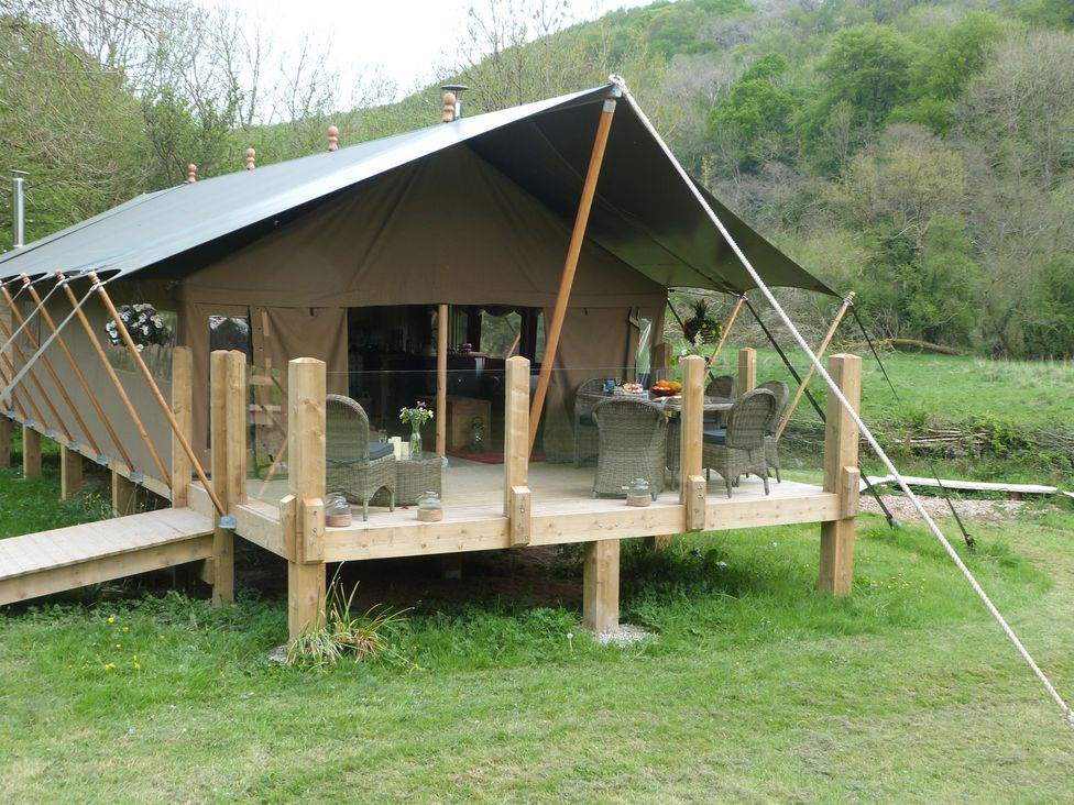 A tent with a deck and furniture outside at Ceri in Newcastle Emlyn