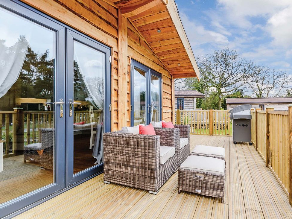A deck with seating and sliding doors at Typhoon Lodge in Winchester