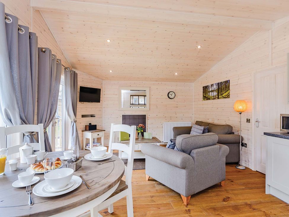 A living room with a sofa and television at Typhoon Lodge in Winchester