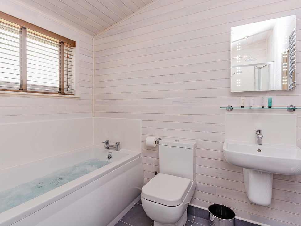 A bathroom with a bathtub, toilet, and sink at Typhoon Lodge in Winchester