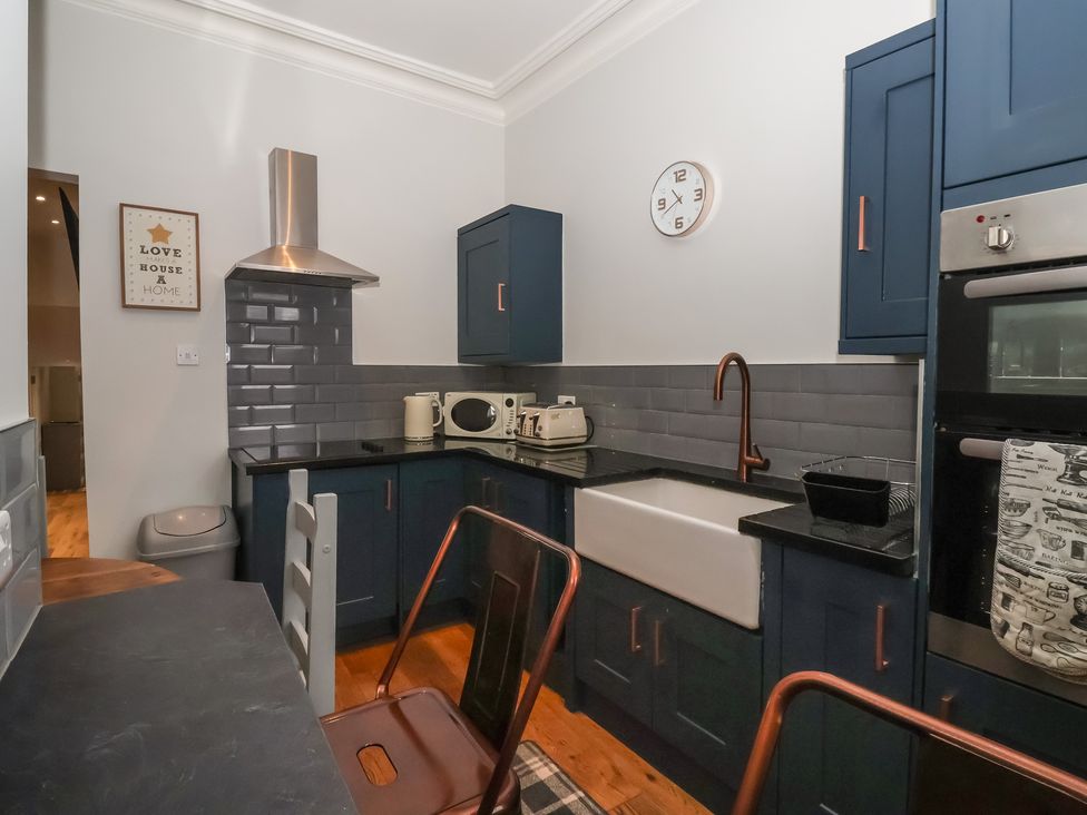 A kitchen with a sink, cabinets, and appliances at Flat 2 23 Hyde Park Road Harrogate