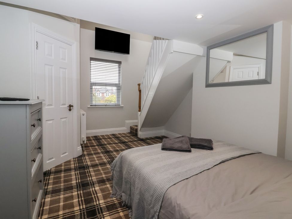 A bedroom with a bed and a dresser at Flat 2 23 Hyde Park Road Harrogate
