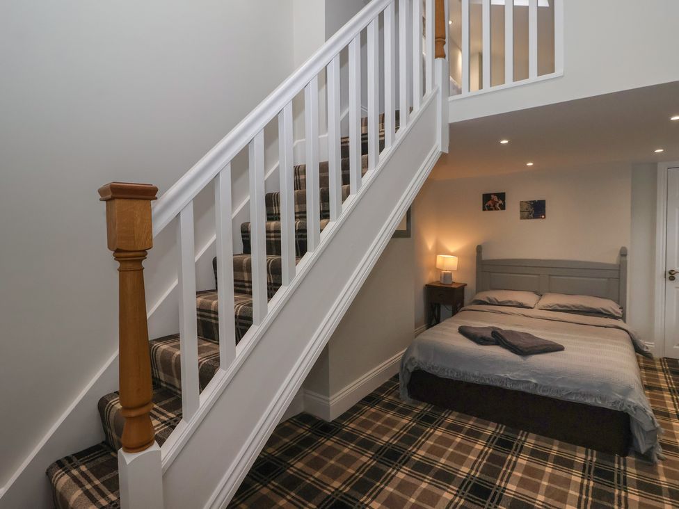 A bedroom with bed and stairs at Flat 2 23 Hyde Park Road Harrogate