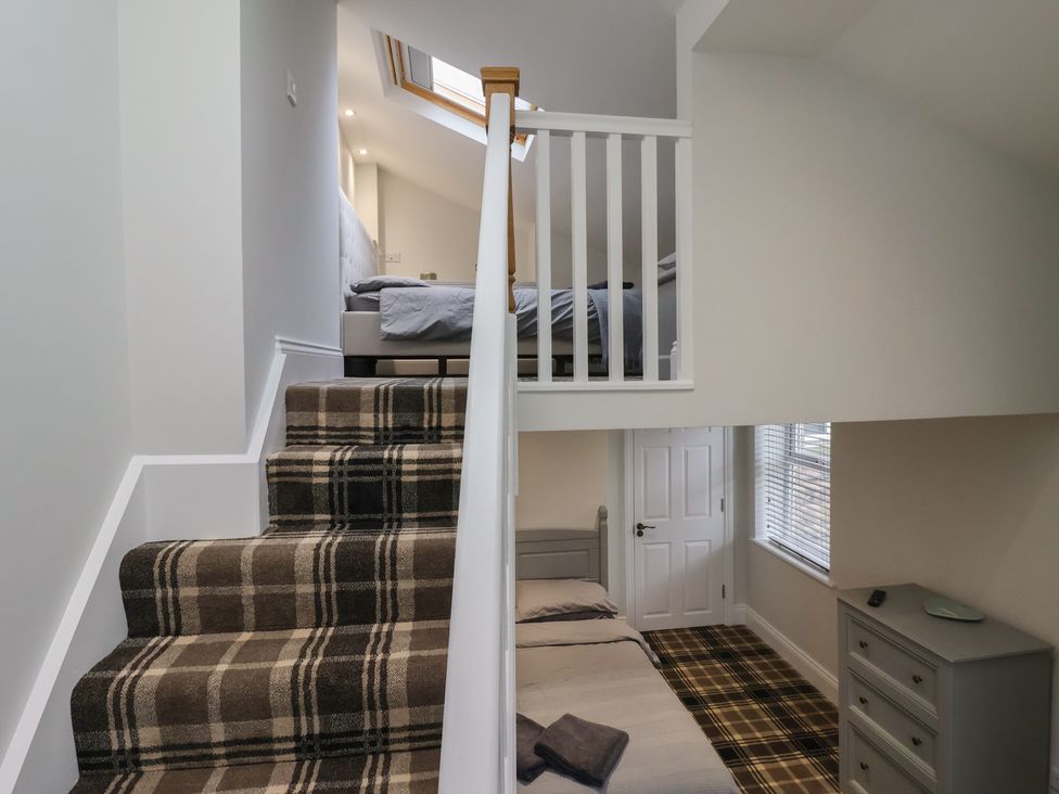 A bedroom with stairs and two beds at Flat 2 23 Hyde Park Road Harrogate